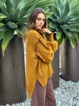 Sweater de lana color rosado, con cuello alto y detalles de volados en los hombros y puños.