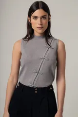 Musculosa negra con cuello alto y detalle de botones decorativos en el lateral.