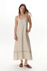 Vestido largo color crudo con breteles finos y costuras a la vista en color azul.