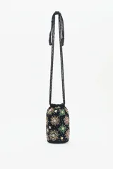 Cartera tipo tote bag de terciopelo negro con bordados de flores y estrellas de lentejuelas y mostacillas de colores. Tiene doble asa de cordón trenzado negro con cuentas en los extremos.