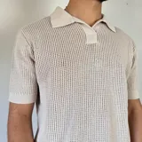 Chomba de punto color marrón con cuello polo y mangas cortas.