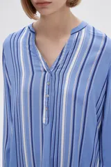 Blusa color crudo con rayas verticales grises, cuello mao con abertura en V y mangas largas.