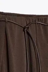 Falda midi marrón de tejido tipo punto con cintura con trabillas y cinturón efecto piel ajustable con lazadas.