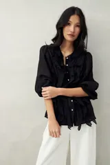 Camisa negra de tencel liviana con volados románticos y manga corta.