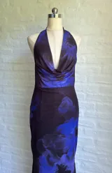 Vestido largo de fiesta con estampado floral en tonos azul y negro, escote halter y espalda descubierta.