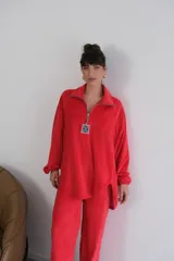 Buzo rojo de plush terciopelo con cierre parcial frontal y detalle de etiqueta con logo en el pecho.