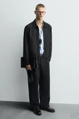 Bolso tipo shopper fabricado en cuero color negro. Tiene un bolsillo interior plano con cierre mediante cremallera y asas de cuero.