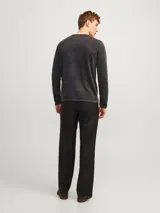 Sweater de punto gris oscuro con cuello redondo y mangas largas. Tiene un acabado de lavado ácido que le da un aspecto deslavado y una superficie más suave.