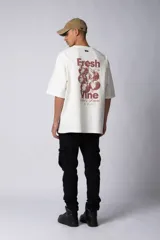 Remera color beige de corte oversize, con cuello redondo y mangas cortas. Estampa pequeña en el frente con la frase "Fresh from the vine".