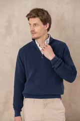 Sweater azul de algodón pigmentado con medio cierre y cuello alto.