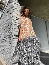 Vestido camisero largo con estampado de hojas en tonos marrones y blancos en la parte superior, y estampado de cebra en blanco y negro en la parte inferior.