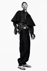 Pantalón bombacho de denim azul oscuro, tiro alto, con bolsillos delanteros y puños con botón en los tobillos. Cierre frontal con cremallera y botones metálicos.