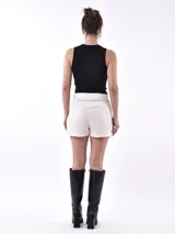 Musculosa negra ajustada al cuerpo, con cuello redondo y ribete blanco en el borde del cuello.