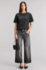 Remera negra de algodón con cuello redondo y mangas cortas. Estampado frontal con la frase "Take me back stage" con apliques brillantes.