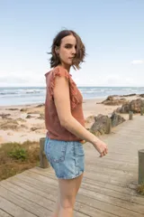 Musculosa tejida color marrón con diseño calado y flecos en los hombros.