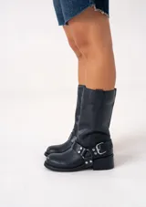 Bota de cuero marrón oscuro con caña media, estribo desmontable y hebilla metálica. Taco de madera de 5cm y suela de caucho.