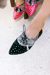 Zapato blucher de terciopelo negro con estampado de estrellas plateadas, puntera plateada brillante y cordones negros. Interior de cuero y suela de cuero.