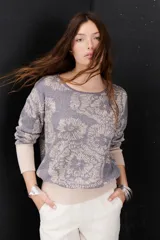 Sweater de punto color gris con estampado de flores en color crema, cuello redondo y mangas largas con puños ajustados.