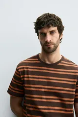 Camiseta marrón con rayas horizontales color naranja, de corte relaxed fit, cuello redondo a contraste y manga corta.