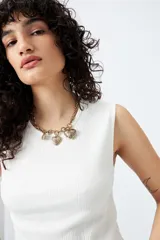 Musculosa blanca de punto acanalado con calce al cuerpo y terminación cropped.