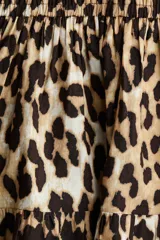 Vestido corto sin mangas en tejido fresco de algodón con estampado animal print. Modelo con escote cruzado en V, pliegues en los hombros, cintura fruncida y pollera con vuelo.