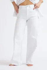 Pantalón de jean blanco de tiro alto, corte ancho (wide leg) y largo hasta el suelo.
