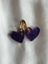 Aros colgantes con forma de corazón, hechos de acrílico negro y con cierre de aro plateado.