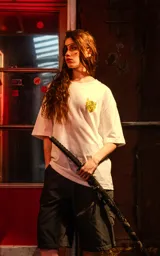 Remera blanca de corte holgado con un pequeño estampado amarillo en el pecho, inspirado en la película Kill Bill.