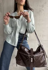 Camisa celeste con bordado inglés, cuello mao y mangas largas abullonadas con puños elásticos.