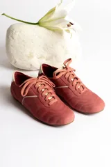 Zapatillas acordonadas color beige con detalles en blanco.