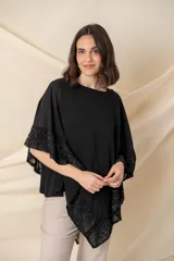 Blusa tipo poncho color gris con zócalo de tul bordado con motivos florales negros. Incluye una camiseta interior de spandex.
