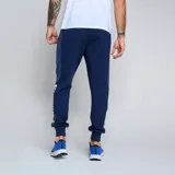 Pantalón de jogging azul marino con puños ajustados, cintura elástica con cordón y bolsillos laterales. Presenta el escudo del Club Nacional de Football y el logo de Umbro.