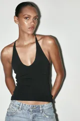 Top negro de cuello halter con escote pico y tiras finas en la espalda.