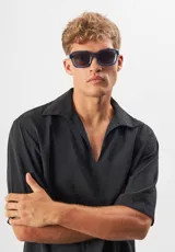 Lentes de sol Eco Shades modelo Romano con montura cuadrada azul traslúcido y lentes grises. Fabricados con acetato biodegradable y lentes de PMMA reciclado.