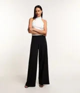 Blusa blanca sin mangas con cuello alto halter, botón en la parte de atrás del cuello, fruncidos laterales y efecto brilloso.