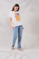Remera blanca de corte holgado con estampado frontal de un recuadro violeta con la frase "Au jour d'hui!" en letras color naranja.