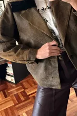 Campera bomber marrón de cuero ovino vintage, con cuello de piel sintética negra desmontable y cierre frontal con cremallera.