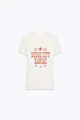 Camiseta blanca de manga corta con cuello redondo y estampado rojo con el texto "DDG USA Dodge City Kansas" y estrellas.