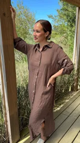 Vestido camisero largo de lino blanco, con corte en la cintura, abertura lateral y botones de nácar.