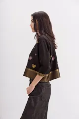 Camisa negra de viscosa con jacquard de lurex, calce amplio y escote redondo. Presenta bordados de corazones dorados y rosados, y guardas doradas en el ruedo y los puños.