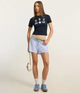 Remera baby look azul marino con estampado frontal de letras "USA" apiladas verticalmente sobre el número "20" y el número "08" separados por una estrella blanca.