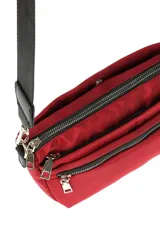 Bandolera rectangular color bordó, con correa larga regulable de cinta negra. Tiene dos compartimentos principales con cierre y un bolsillo frontal con cierre.