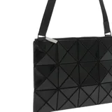 Bandolera negra con diseño geométrico facetado, cierre superior con cremallera y correa de hombro ajustable.