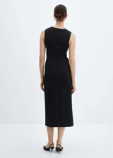 Vestido midi color beige, sin mangas y con detalle de nudo en la cintura.