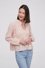 Blusa blanca con rayas verticales, cuello con lazo, mangas largas y corte holgado.