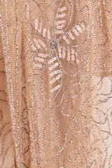 Blusa semitransparente color beige con bordados de hilo metalizado y abalorios. Tiene mangas cortas y cierre frontal con cordones.