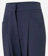 Pantalón de vestir azul marino, de corte wide leg, con cintura alta, bolsillos laterales y traseros. Se ajusta a la cintura con cinturón de cuero marrón.