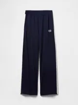 Pantalón deportivo azul marino de corte recto, con cintura elástica, bolsillos laterales y logo de Gap bordado en blanco. Presenta una franja blanca vertical en los laterales.