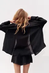 Camisa color durazno confeccionada en algodón, de corte amplio, con cuello solapa, manga larga con puños abotonados, hombros caídos, bolsillo de parche en el pecho, pinzas en la espalda y cierre frontal con botones.