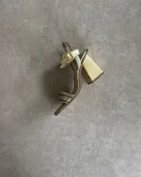 Sandalia de fiesta dorada con tiras finas cruzadas en el empeine, pulsera con hebilla al tobillo y taco geométrico.